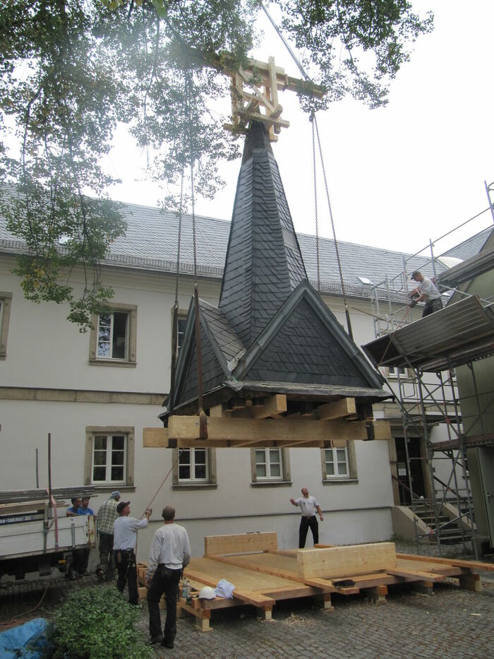 Heben einer sanierten Turmspitze Heben einer sanierten Turmspitze…